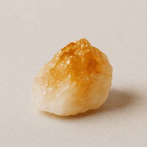 Goldgelber Citrin-Rohstein auf hellem Hintergrund – Symbol für Optimismus, Selbstvertrauen und inneren Reichtum